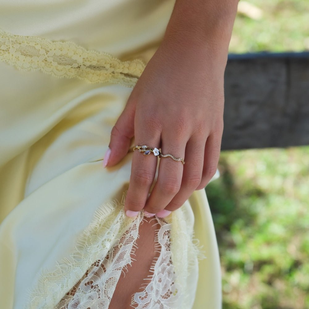 Anillo dorado con flor blanca de cristal