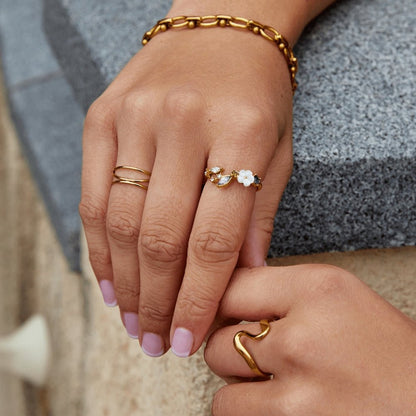 Anillo dorado con flor blanca de cristal